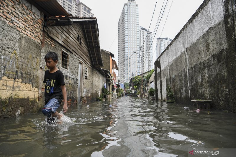 Seorang warga melintasi banjir di Jalan Pondok Jaya, Kelurahan Pela Mampang, Kecamatan Mampang Prapatan, Jakarta Selatan, Rabu (1/1/2020). (ANTARA/Laily Rahmawaty)