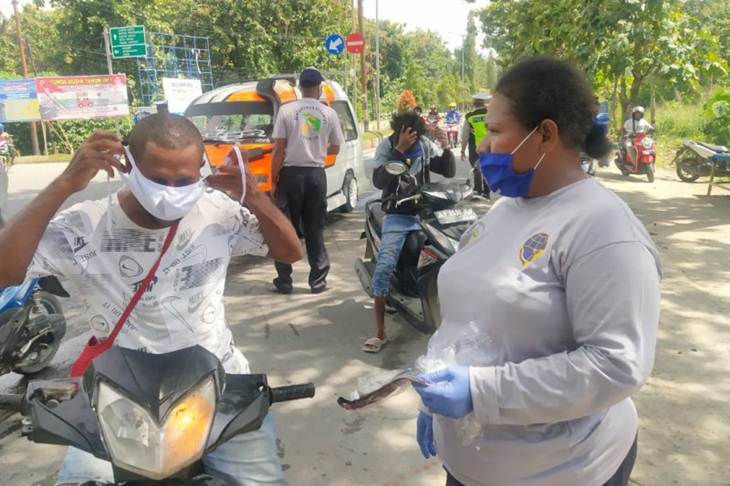Suasana petugas Dinas Perhubungan Kabupaten Jayapura saat memakaikan masker pada sala seorang pengendara motor di jalan Kemiri Sentani, Selasa (19/5). (ANTARA/HO/Humas Tim Gugus Tugas COVID-19 Kabupaten Jayapura)