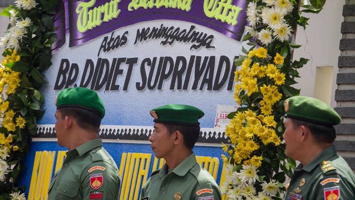 Anggota TNI berdiri di depan karangan bunga duka cita atas meninggalnya Didiet Supriyadi. (ANTARA FOTO/Mohammad Ayudha)