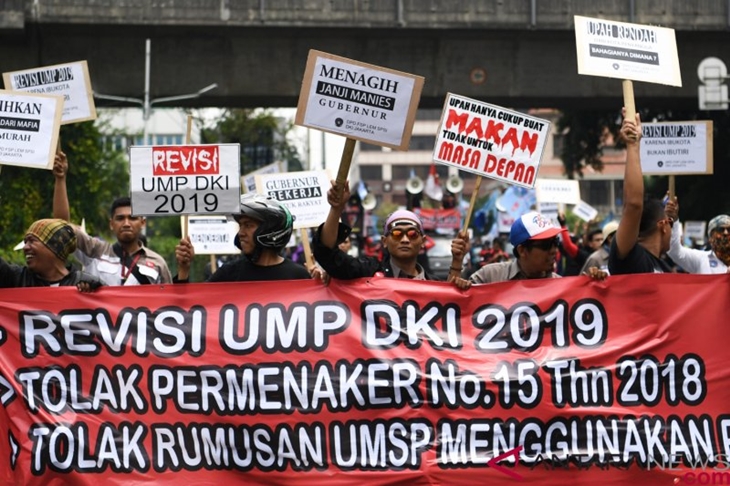 Massa dari sejumlah elemen buruh melakukan aksi menuju Balai Kota Jakarta, Selasa (18/12/2018). Aksi yang diikuti ratusan buruh tersebut mendesak pemerintah merevisi upah minimum provinsi (UMP) DKI Jakarta tahun 2019 serta menolak formula PP 78 tahun 2015. ANTARA FOTO/Wahyu Putro A/aww.