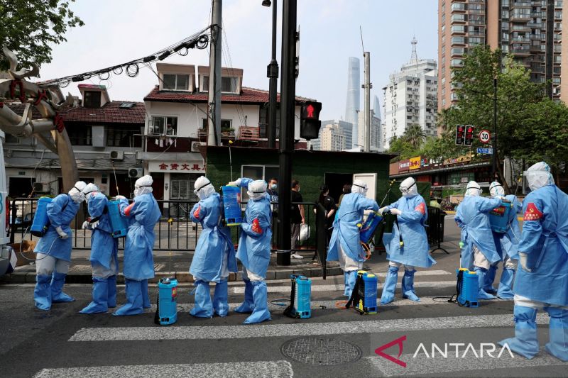 Para petugas dengan alat pelindung diri bersiap melakukan disinfeksi di kawasan pemukiman distrik Huangpu, menyusul wabah penyakit virus corona (COVID-19) di Shanghai, China, Rabu (20/4/2022). China Daily via REUTERS/RWA/djo