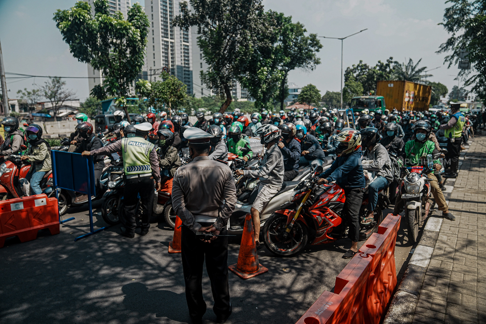 Petugas Kepolisian Polda Metro Jaya melakukan pembatasan mobilitas dari arah Tangerang menuju Jakarta saat hari pertama pelaksanaan PPKM Darurat di wilayah Kalideres, Jakarta, Sabtu, (3/7). MP/Rizki Fitrianto
