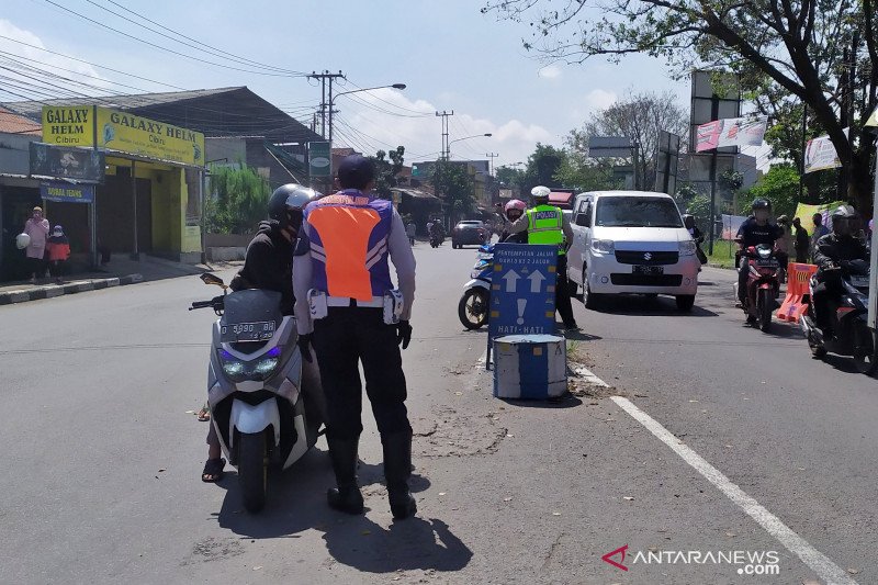 Petugas Dinas Perhubungan dan aparat kepolisian memeriksa kendaraan yang hendak masuk ke Kota Bandung di Bundaran Cibiru. (ANTARA/Bagus Ahmad Rizaldi)