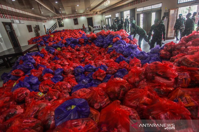 Prajurit TNI AD memindahkan paket bahan pangan dan sembako di rumah dinas walikota Palangkaraya, Kalimantan Tengah, Selasa (21/4/2020). Pendistribusian bantuan penanganan COVID-19 dari pemerintah setempat berupa 13.500 paket bahan pangan dan sembako itu akan di bagikan gratis untuk warga setempat yang terdampak COVID-19. ANTARA FOTO/Makna Zaezar/pras.