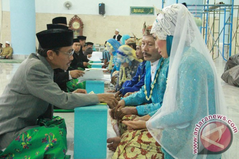 Sebanyak 34 pasang pengantin melakukan acara akad nikah masal di di masjid Al'Anas, Lumajang, Jatim, Rabu (26/12). Nikah masal ini diadakan oleh kantor Kementerian Agama Lumajang, yang bekerjasama dengan persatuan perias pengantin Lumajang, dalam rangka Peringatan hari jadi ke-757 Kota Lumajang. (FOTO ANTARA/Cucuk Donartono)