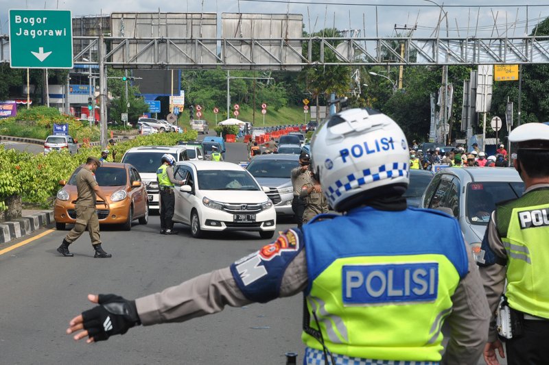 Ilustrasi polisi menyuruh pengemudi memutar-balik kendaraannya selama masa PSBB. ANTARA FOTO/Arif Firmansyah