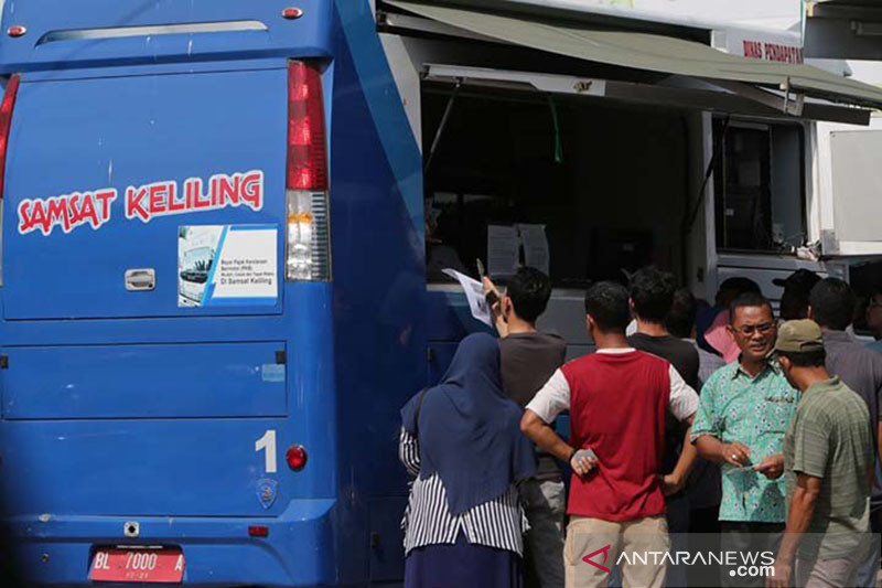 Warga antre mengurus pembayaran pajak kendaraan bermotor pada mobil layanan Samsat keliling. Foto: ANTARA/Irwansyah Putra