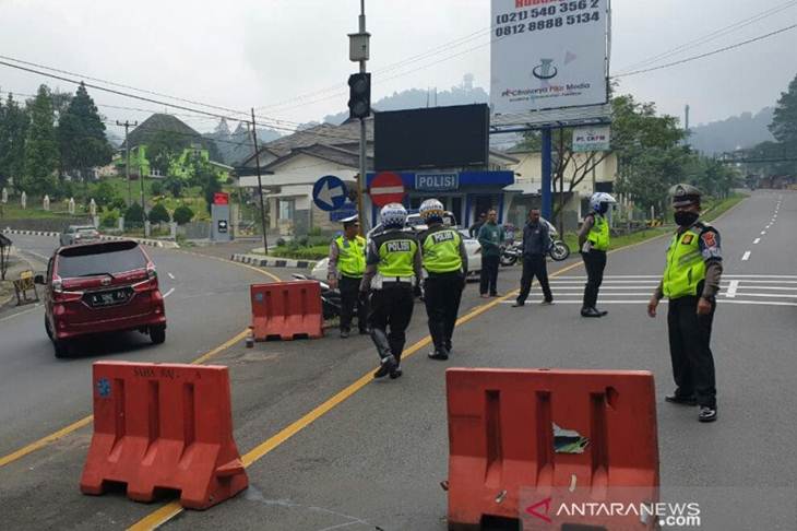 Petugas Satlantas Polres Cianjur, Jawa Barat, mengarahkan kendaraan pendatang dengan tjuan berwisata ke wilayah Cianjur, untuk kembali ke kotanya masing-masing sebagai upaya antisipasi merebaknya COVID-19 di wilayah hukum Cianjru, Senin (30/3) (Ahmad Fikri)