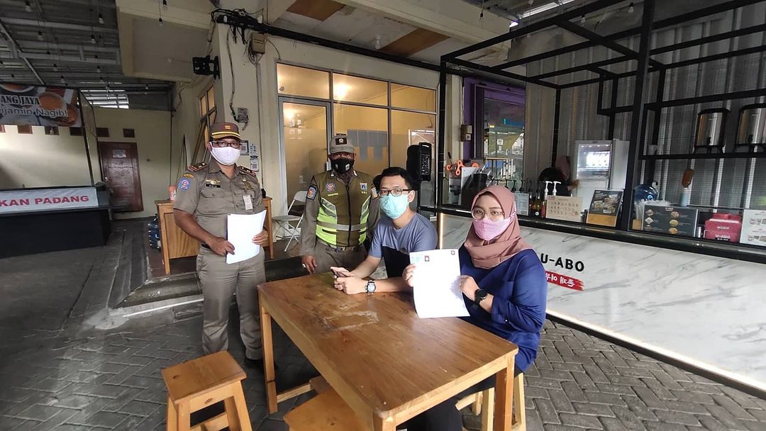 Satpol PP DKI Jakarta melakukan sosialisasi PPKM ( Pemberlakuan Pembatasan Kegiatan Masyarakat ) sesuai Instruksi Menteri Dalam Negeri No. 01 Tahun 2021 di wilayah Pegadungan, Jakarta Barat .