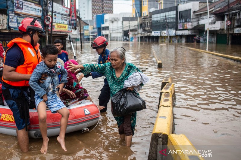 Petugas pemadam kebakaran mengevakuasi warga saat banjir di Jalan Jatinegara Barat, Kampung Pulo, Jakarta, Kamis (2/1/2020). ANTARA FOTO/Aprillio Akbar/pras