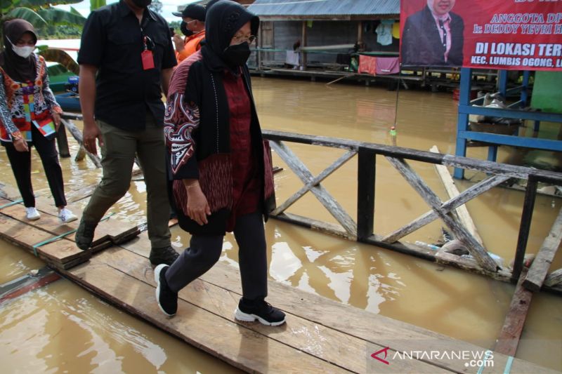 Menteri Sosial Tri Rismaharini meninjau dan menyerahkan bantuan kepada korban bencana banjir di Desa Atap, Kecamatan Sembakung, Kabupaten Nunukan, Kalimantan Utara (Kaltara), Minggu (9/1). ANTARA/HO - Kemensos.